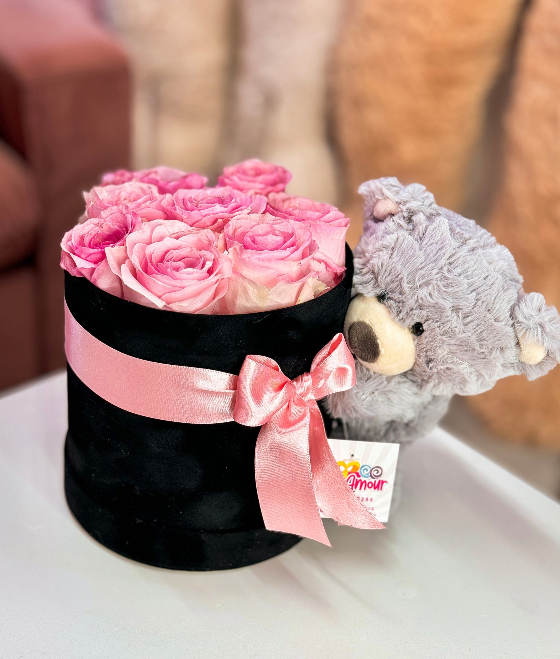 Pink roses with a teddy hugging a velvet box