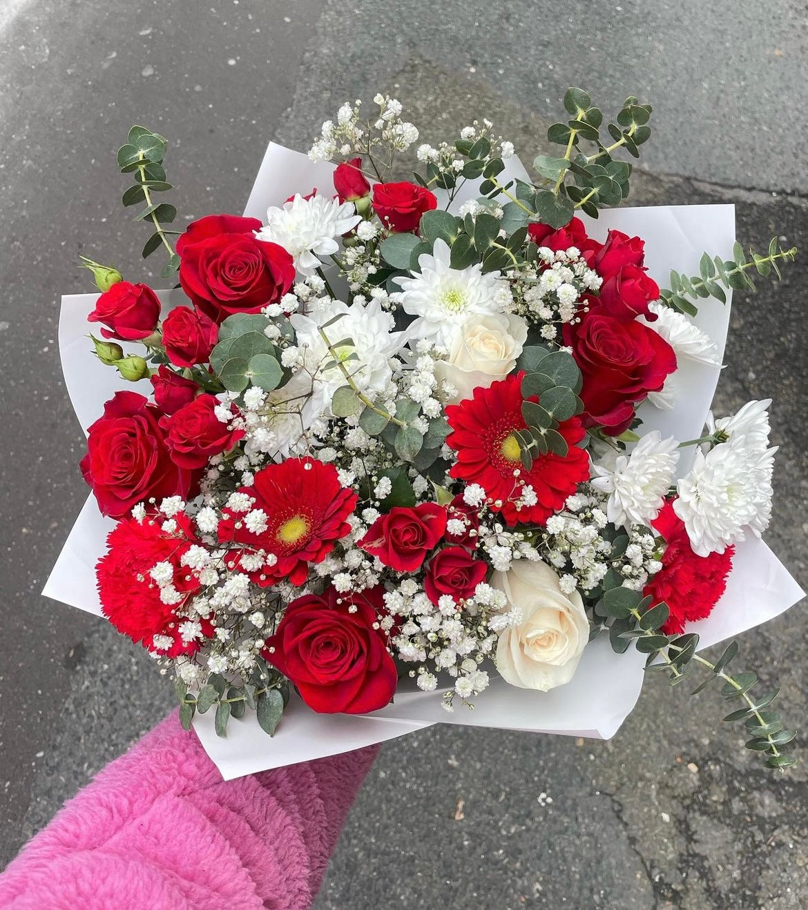 Red, white and green filling flowers wrapped in a bouquet