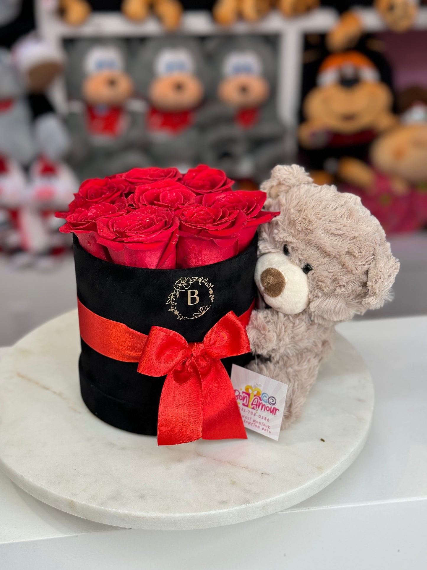 Natural Red roses in a velvet box with a teddy hugging it
